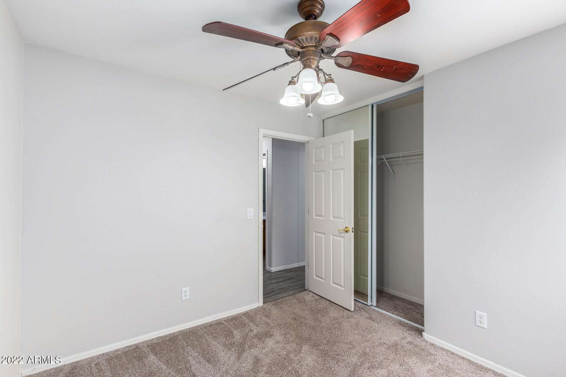 2609 South Devonna Lane Tolleson, AZ 85353 - Photo 21 of 30 an empty room with a chandelier fan and a ceiling fan