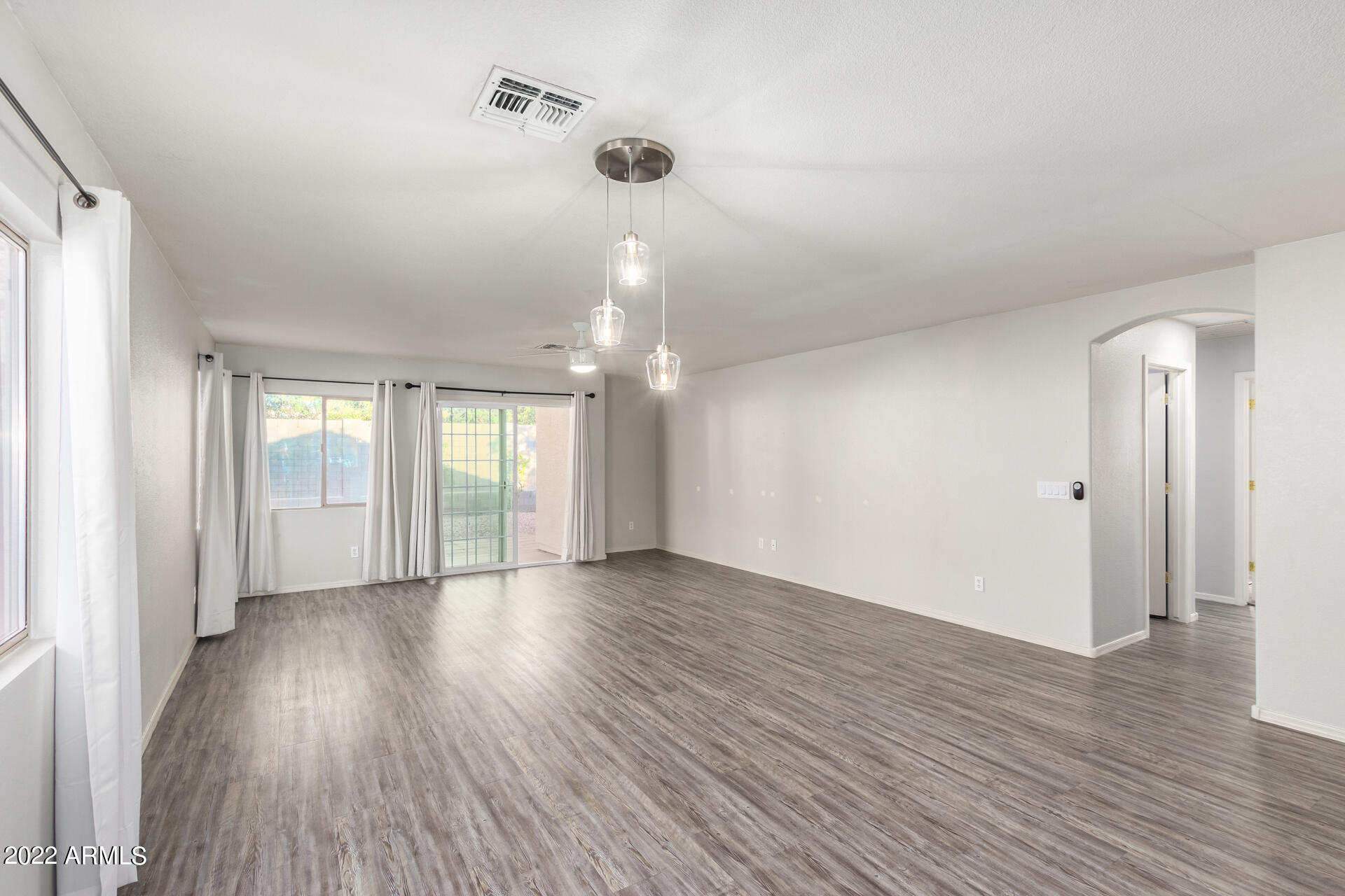 2609 South Devonna Lane Tolleson, AZ 85353 - Photo 6 of 30 a view of an empty room with wooden floor and a window