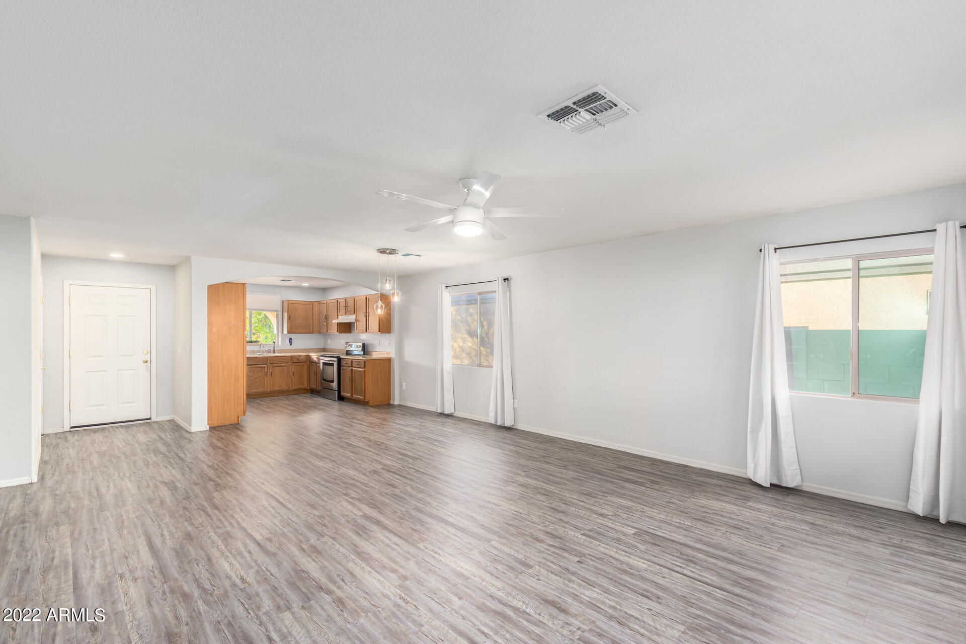 2609 South Devonna Lane Tolleson, AZ 85353 - Photo 8 of 30 a view of a livingroom with wooden floor and a ceiling fan