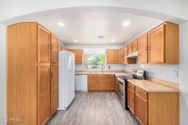 a kitchen with a sink appliances cabinets and counter space