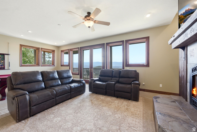 335 Bern Way Midway, UT 84049 - Photo 41 of 88 Spacious room featuring multiple windows with wood trim, a stone fireplace with a wood mantle, recessed lighting, and a ceiling fan