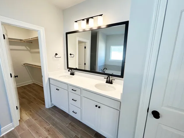 a spacious bathroom with a double vanity sink and mirror