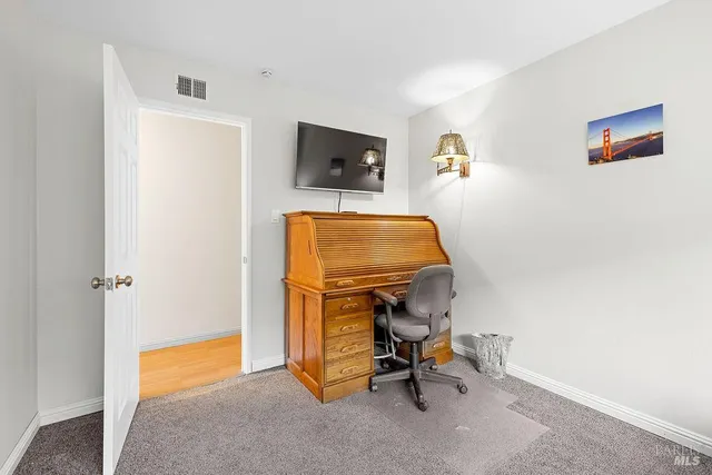 a view of a workspace with furniture and a window