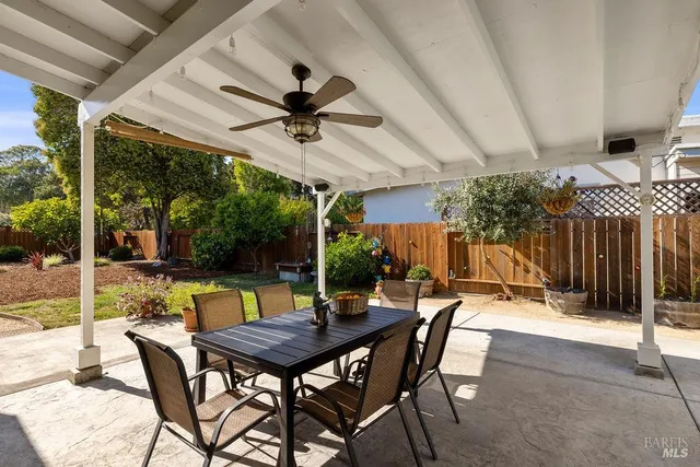 a view of a patio with table and chairs potted plants and a large tree