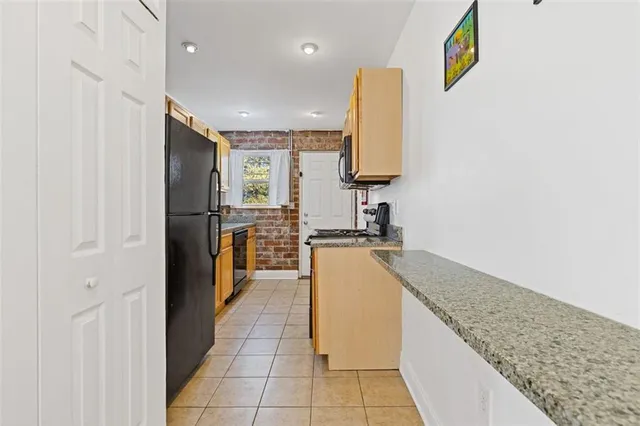 a kitchen with stainless steel appliances granite countertop a refrigerator and a sink