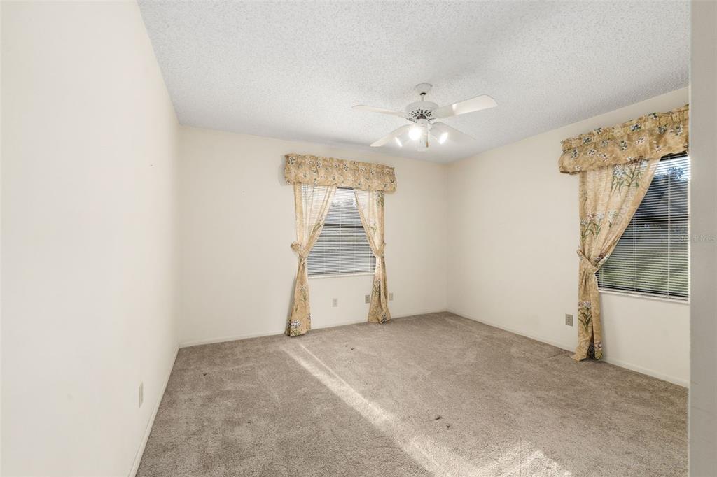11606 Northwest 120th Terrace Alachua, FL 32615 - Photo 6 of 46 an empty room with chandelier fan and windows