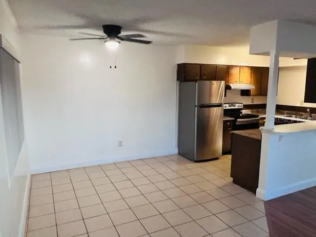 a kitchen with a refrigerator and white cabinets