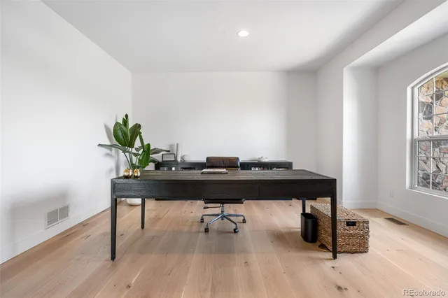 a view of a workspace with furniture and a window