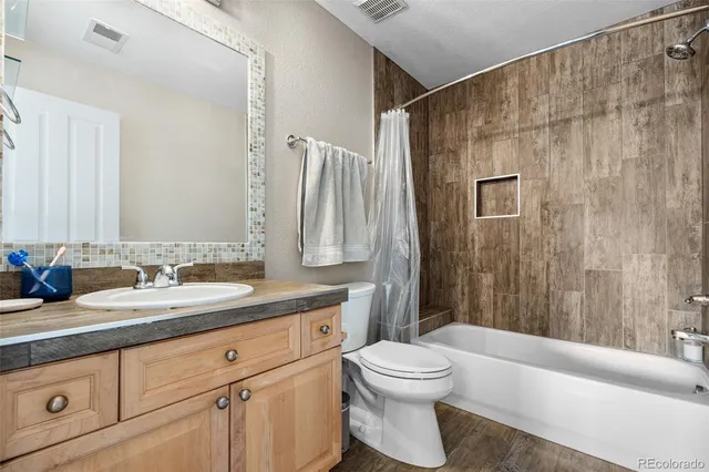 a bathroom with a granite countertop sink a toilet and a bathtub