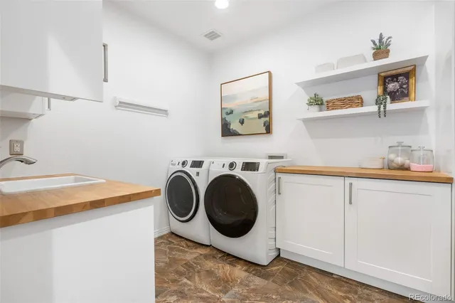 a utility room with sink dryer and washer