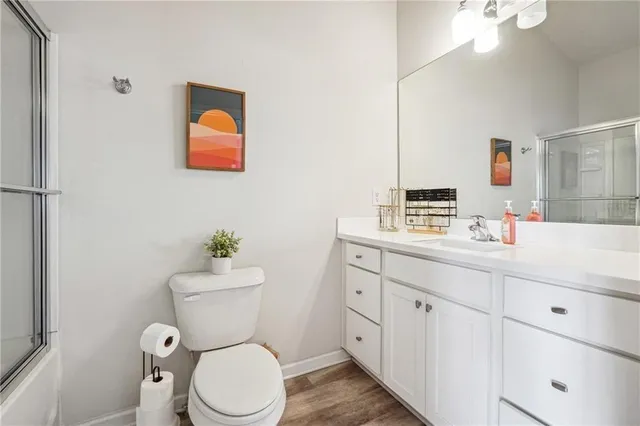 a bathroom with a toilet sink vanity and mirror