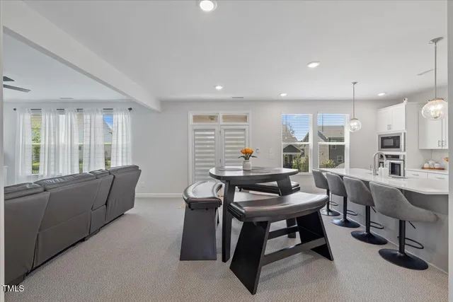 a kitchen with a table chairs refrigerator and cabinets
