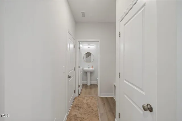 a view of a hallway with a white walls and a white cabinet