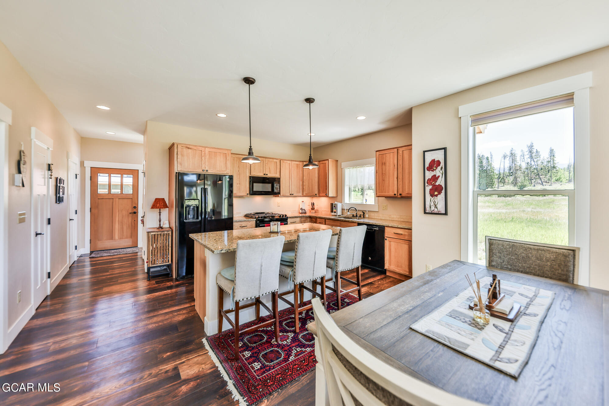 21 Brookside Trail Fraser, CO 80442 - Photo 14 of 62 a living room with dining table and chairs with kitchen view