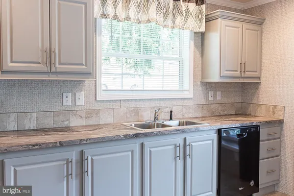 a kitchen with granite countertop white cabinets and a sink