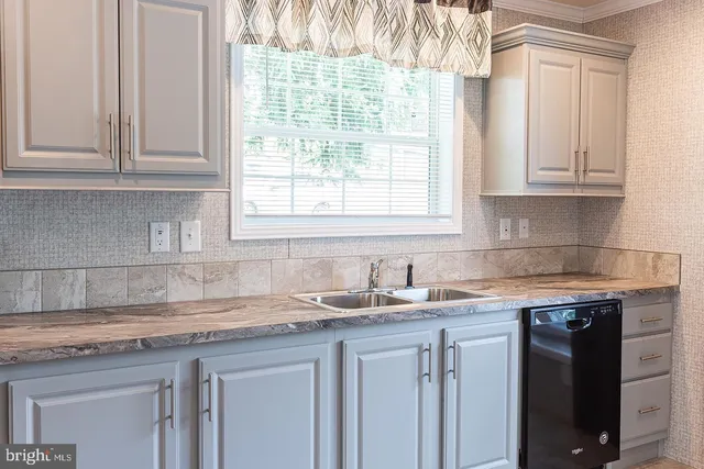 a kitchen with granite countertop white cabinets and a sink