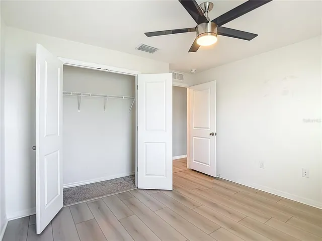 an empty room with a window and a fan