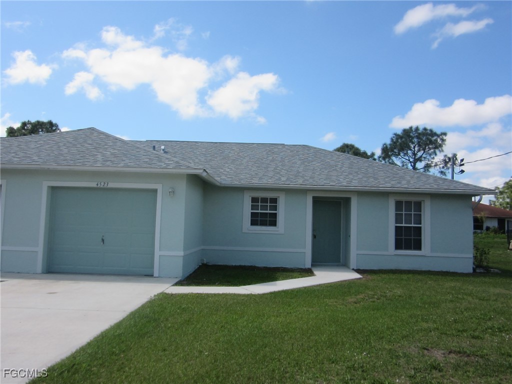 4523 22nd Street Southwest Lehigh Acres, FL 33973 - Photo 1 of 10 front view of a house with a yard