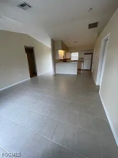 a view of a livingroom with furniture and a refrigerator