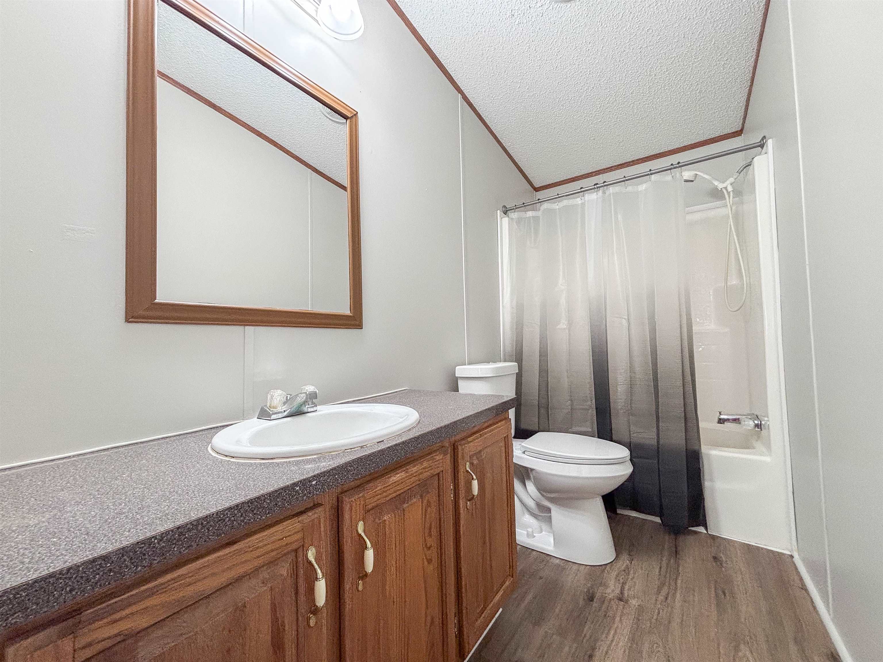 2847 Holly Grove Road Covington, TN 38019 - Photo 25 of 36 Bathroom featuring a wood-finish vanity with a speckled countertop and an integrated sink
