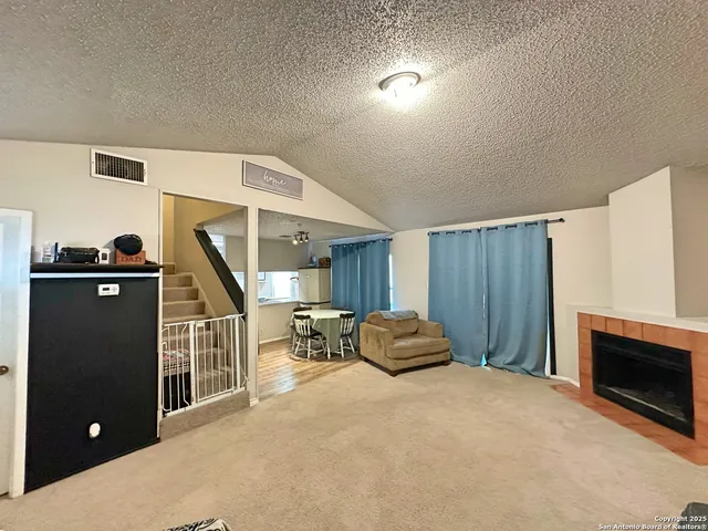a living room with furniture a flat screen tv and a fireplace