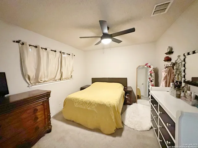 a bedroom with a bed a mirror and dresser
