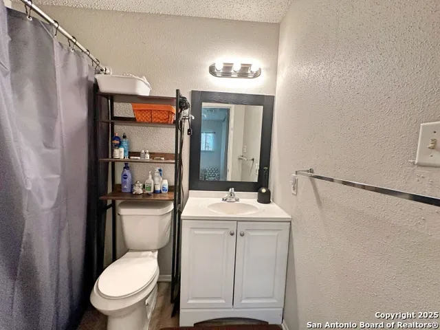 a bathroom with a toilet a sink and a mirror