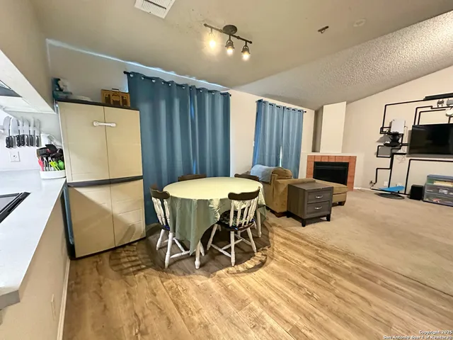 a view of a dining room with furniture a kitchen and chandelier