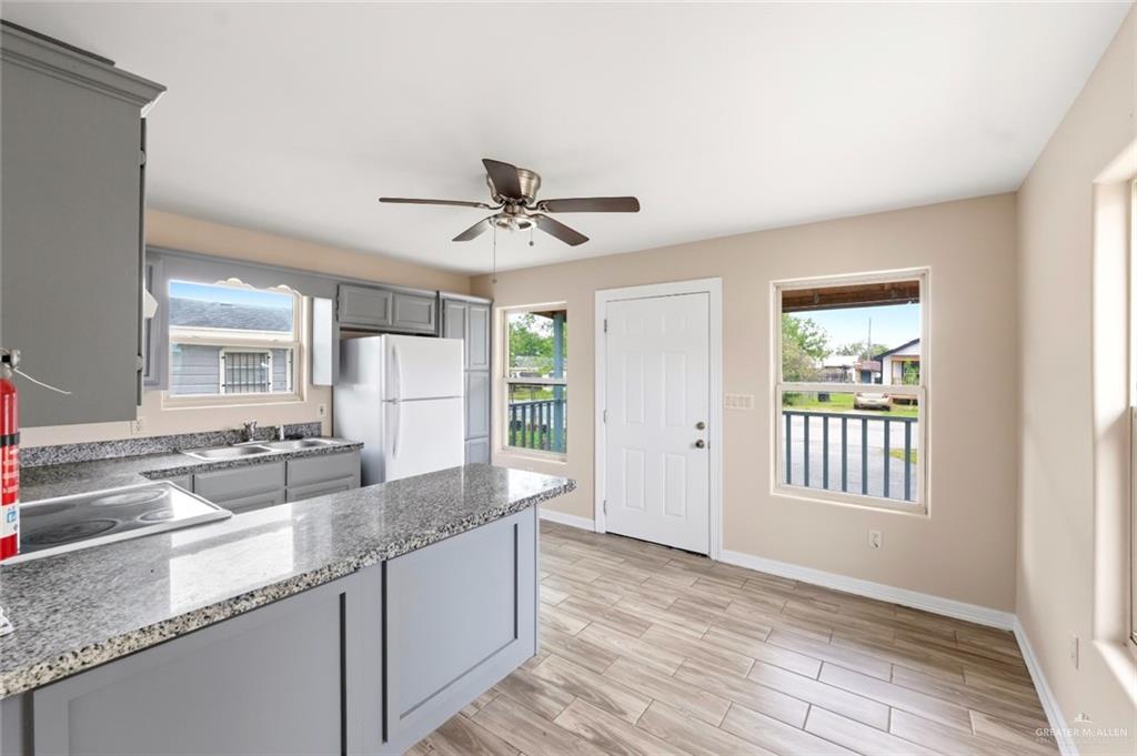 811 Carlson Street Elsa, TX 78538 - Photo 4 of 10 a kitchen with granite countertop a sink and a refrigerator