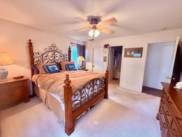 a bedroom with a bed and a flat tv screen on dresser