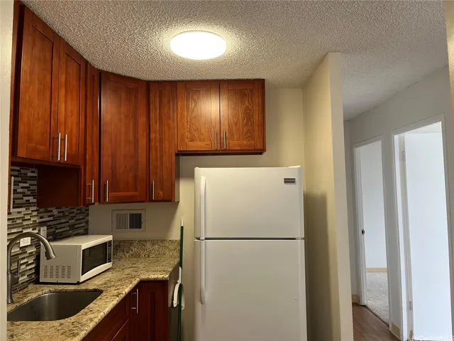 a kitchen with refrigerator a stove a sink and dishwasher with wooden cabinets