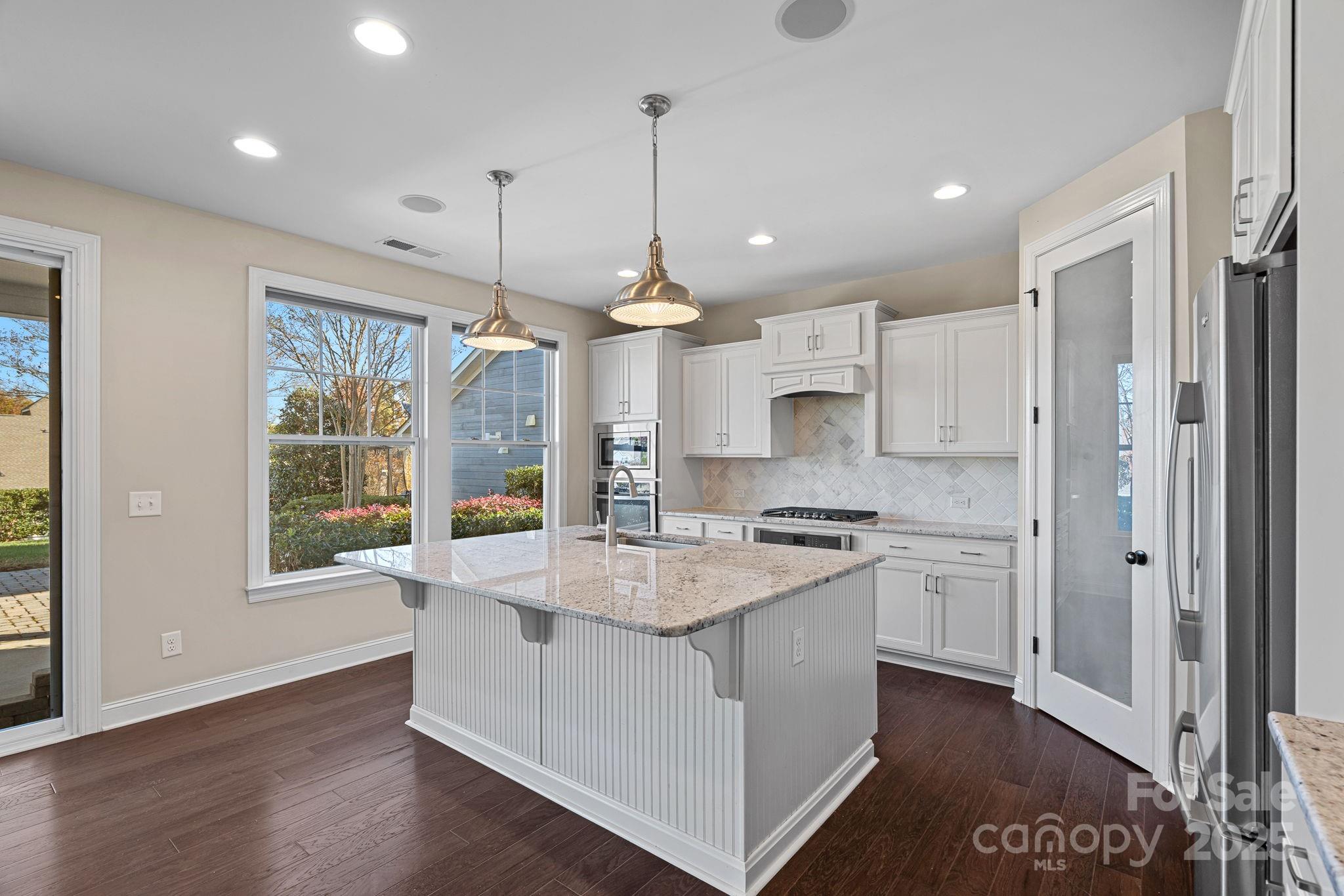 16909 Setter Point Lane Davidson, NC 28036 - Photo 11 of 45 a large kitchen with stainless steel appliances granite countertop a stove a refrigerator a oven and a wooden floor