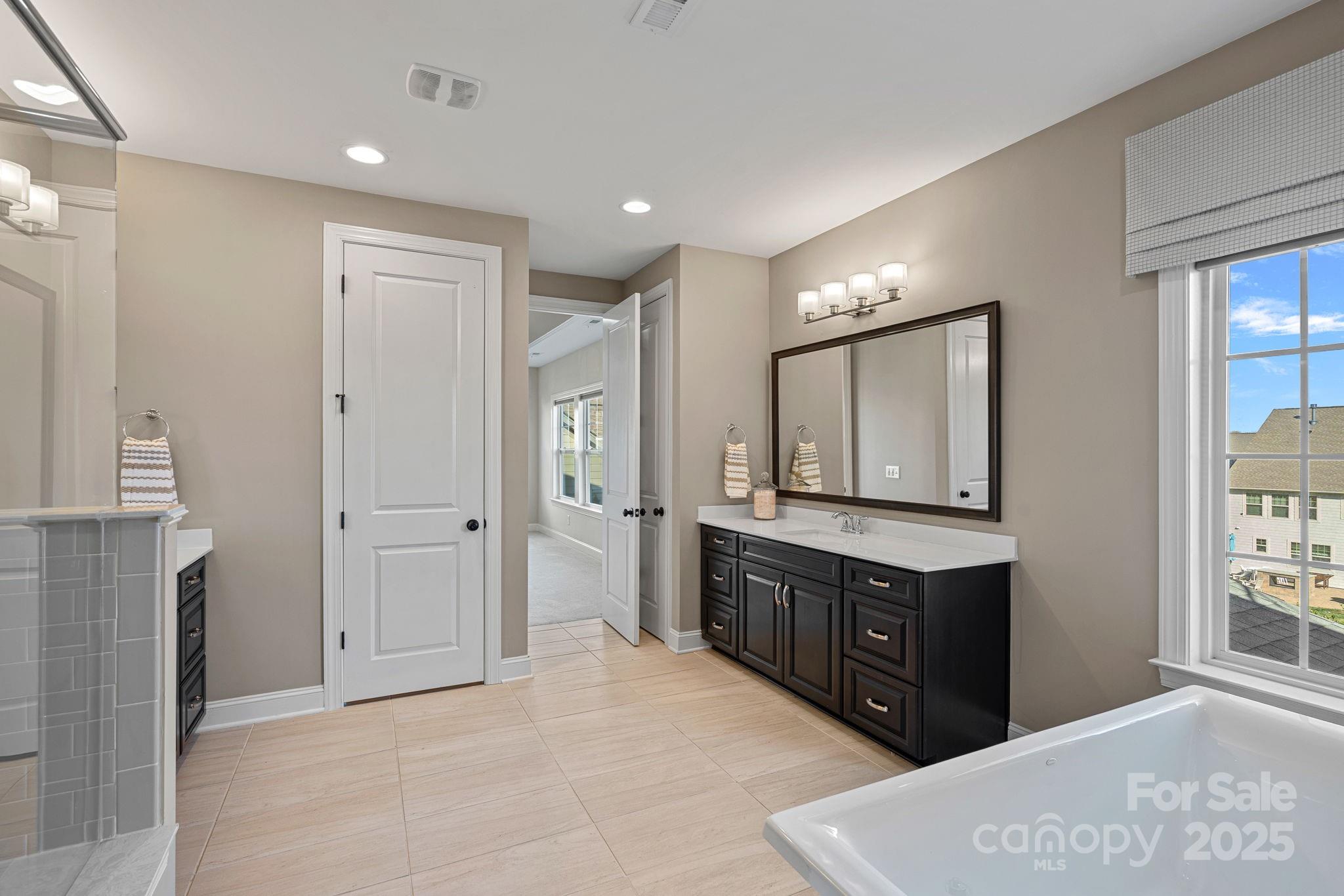 16909 Setter Point Lane Davidson, NC 28036 - Photo 20 of 45 a spacious bathroom with a granite countertop sink a mirror and a shower