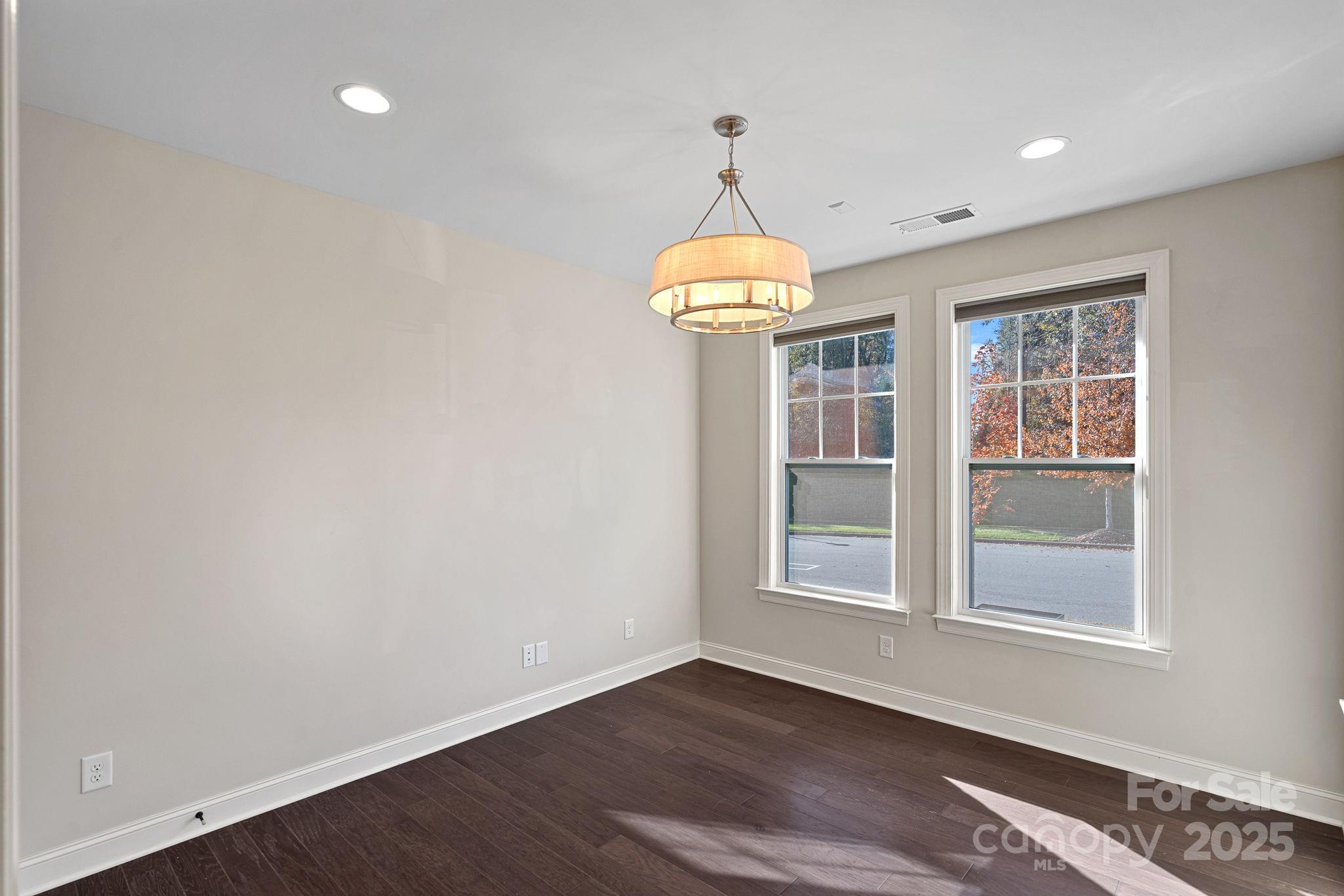 16909 Setter Point Lane Davidson, NC 28036 - Photo 4 of 45 an empty room with wooden floor chandelier and windows