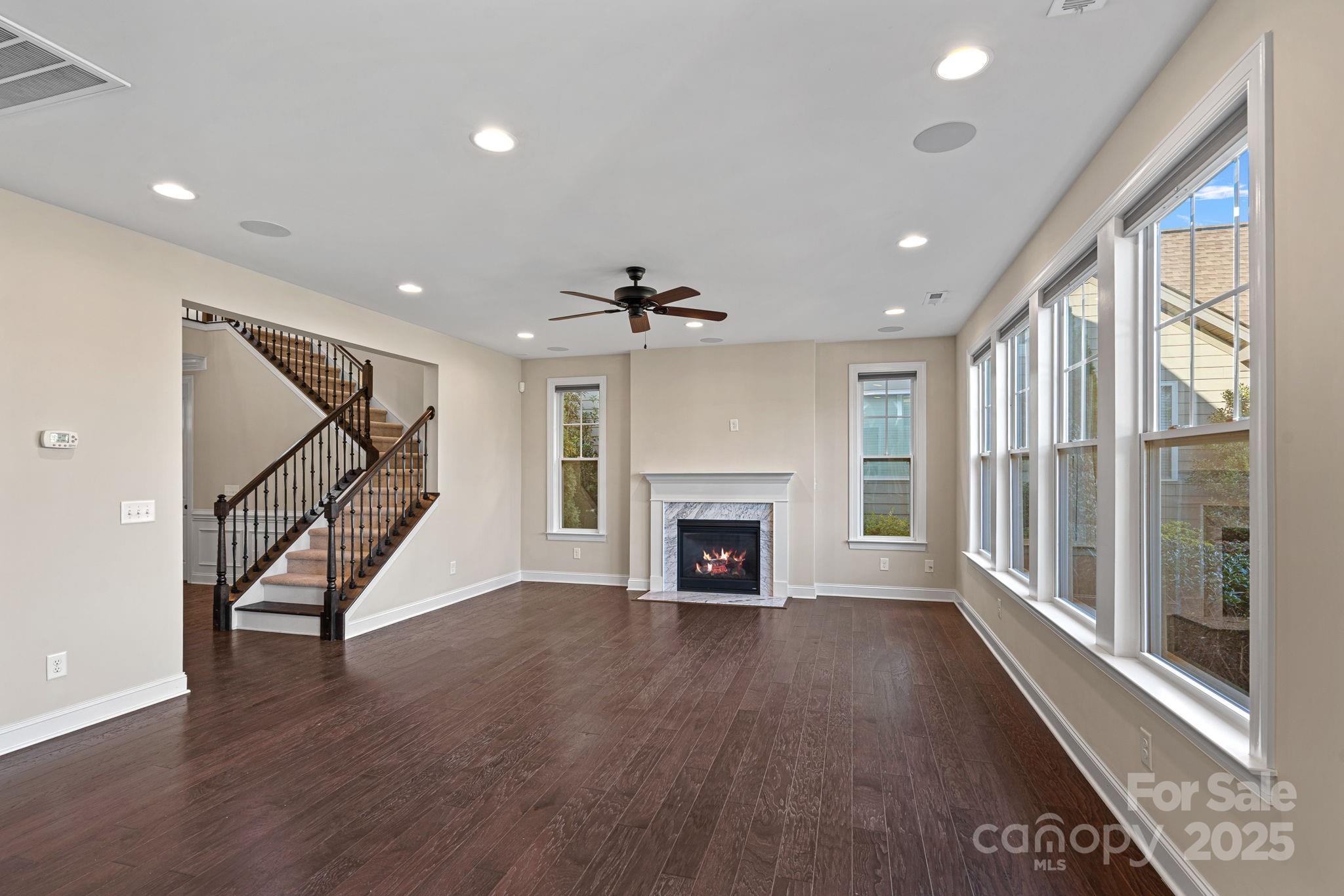 16909 Setter Point Lane Davidson, NC 28036 - Photo 9 of 45 a view of an empty room with wooden floor fireplace and a window