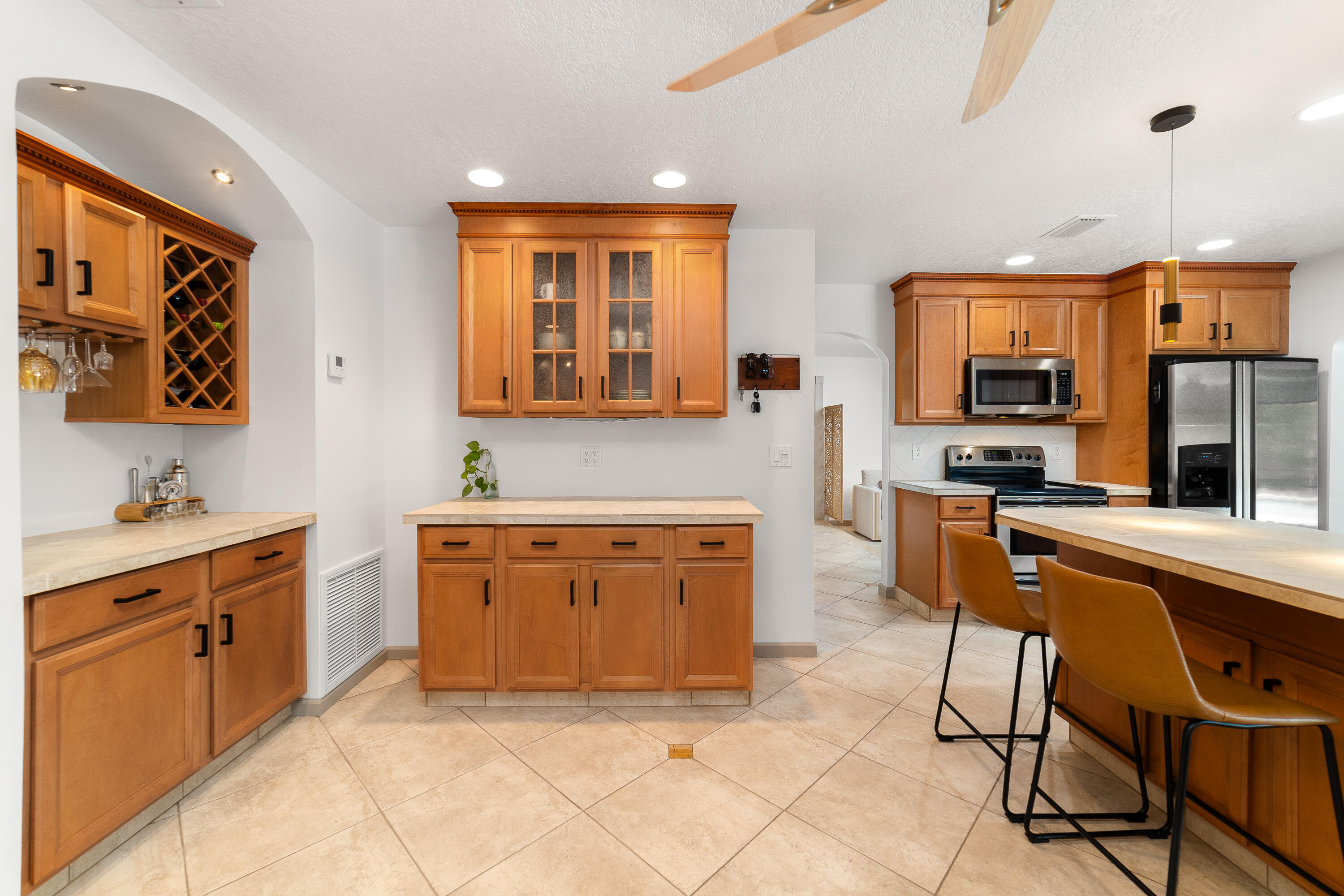 1721 Southwest 9th Street Boca Raton, FL 33486 - Photo 11 of 40 a kitchen with stainless steel appliances granite countertop a stove top oven a sink a dining table and chairs with wooden floor