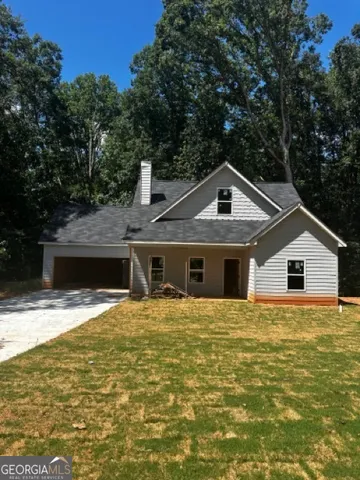a front view of a house with yard and trees