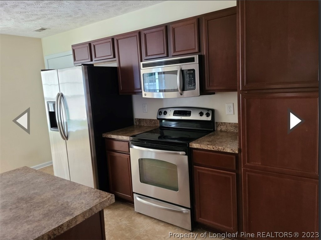 141 Roanoke Drive Raeford, NC 28376 - Photo 5 of 16 a kitchen with stainless steel appliances granite countertop a refrigerator stove and microwave
