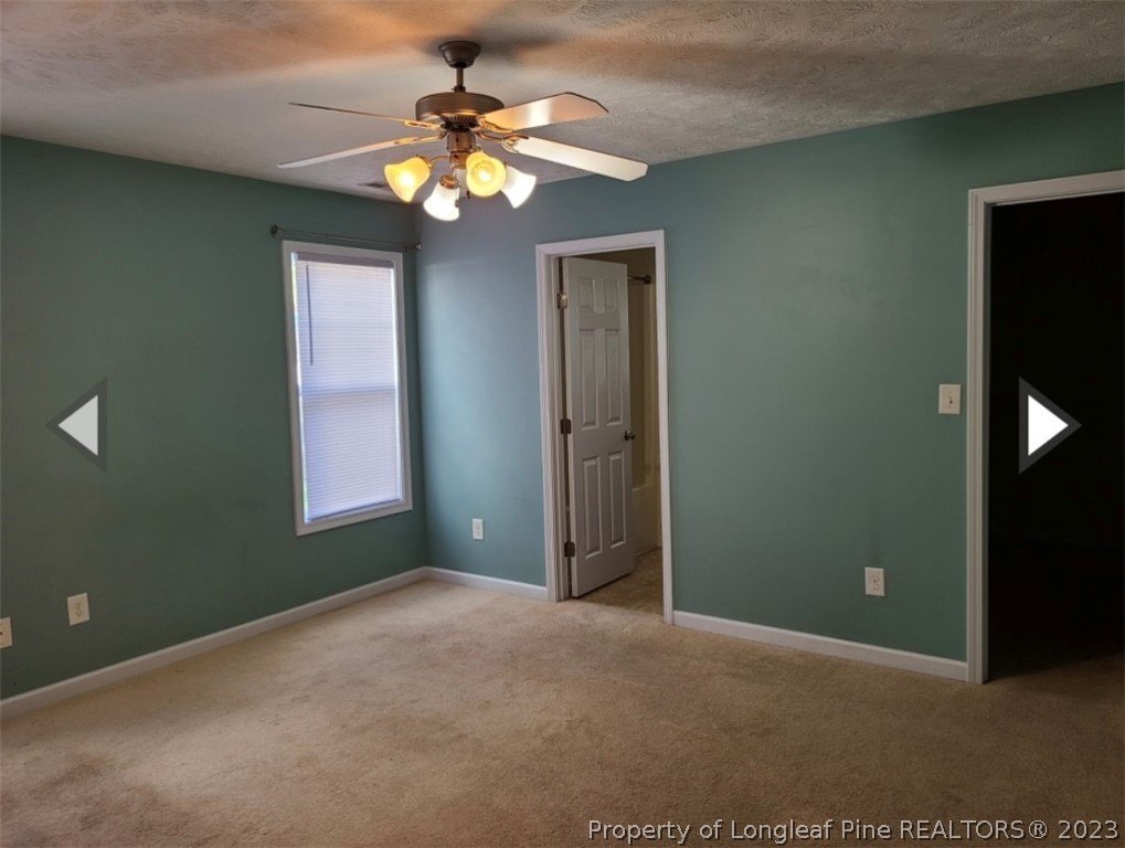 141 Roanoke Drive Raeford, NC 28376 - Photo 9 of 16 an empty room with a chandelier fan and a window
