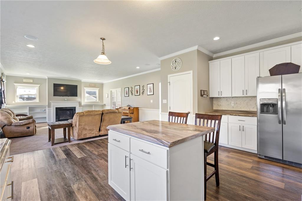 216 West Country Barn Road Houston, PA 15342 - Photo 16 of 34 a open kitchen with stainless steel appliances granite countertop a stove a refrigerator a kitchen island a dining table and chairs with wooden floor