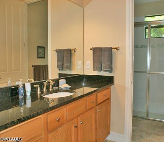 7414 Acorn Way Naples, FL 34119 - Photo 9 of 24 a bathroom with a granite countertop sink and a mirror