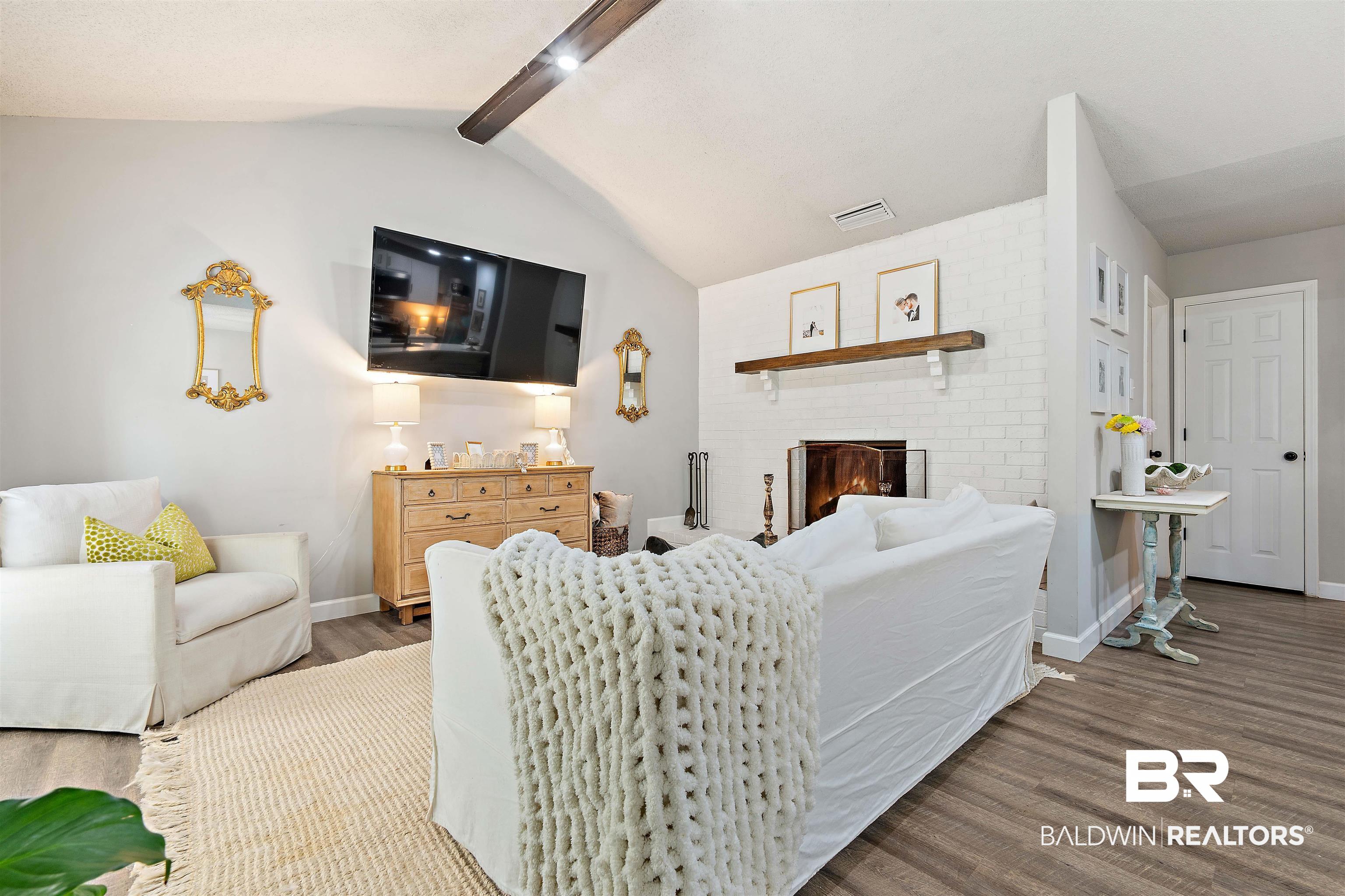 4682 Opal Drive Mobile, AL 36619 - Photo 5 of 27 Living room with lofted ceiling with beams, a fireplace, hardwood / wood-style flooring, and brick wall