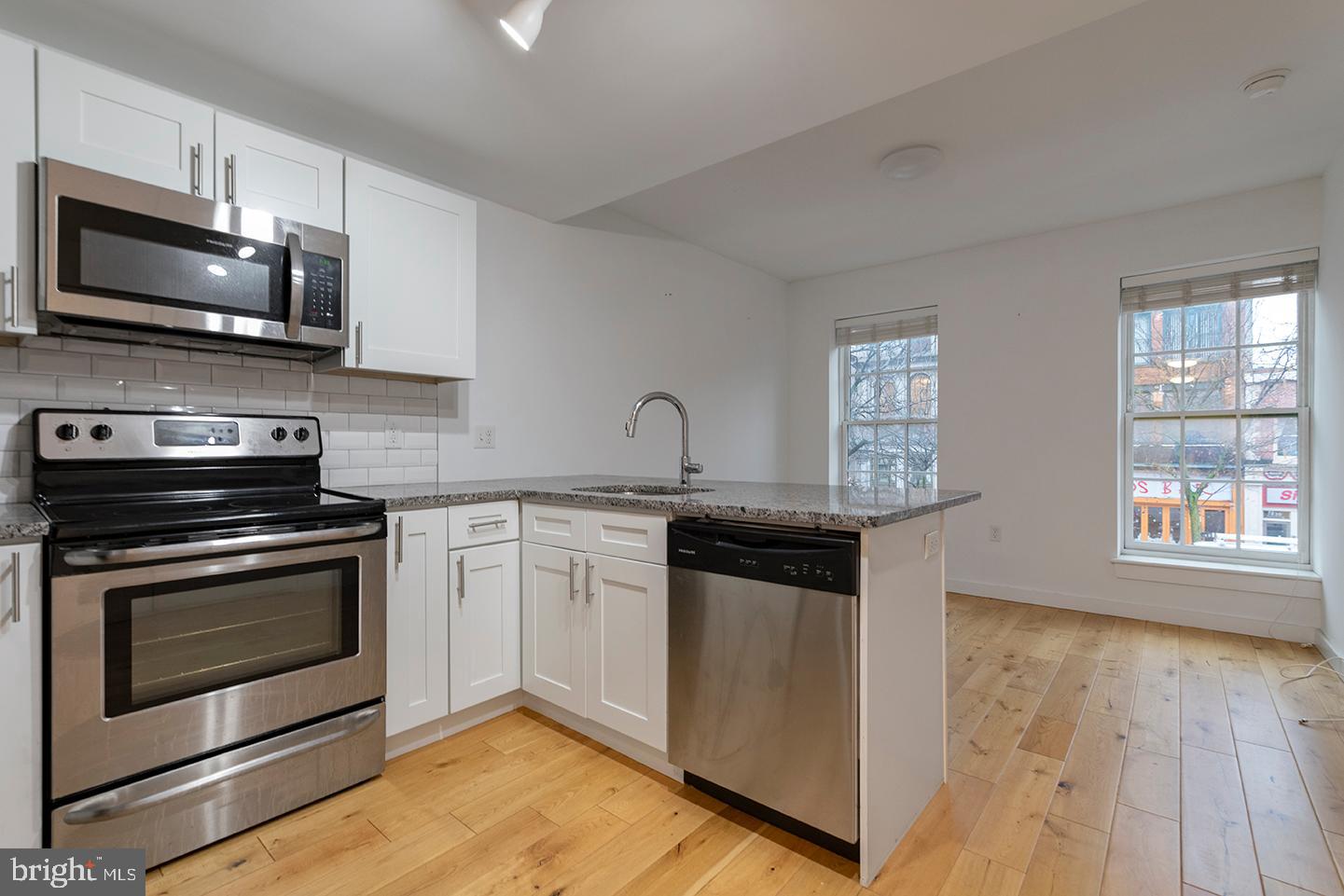 224 Church Street, Unit 203 Philadelphia, PA 19106 - Photo 3 of 15 a kitchen with stainless steel appliances granite countertop a stove a microwave and a sink