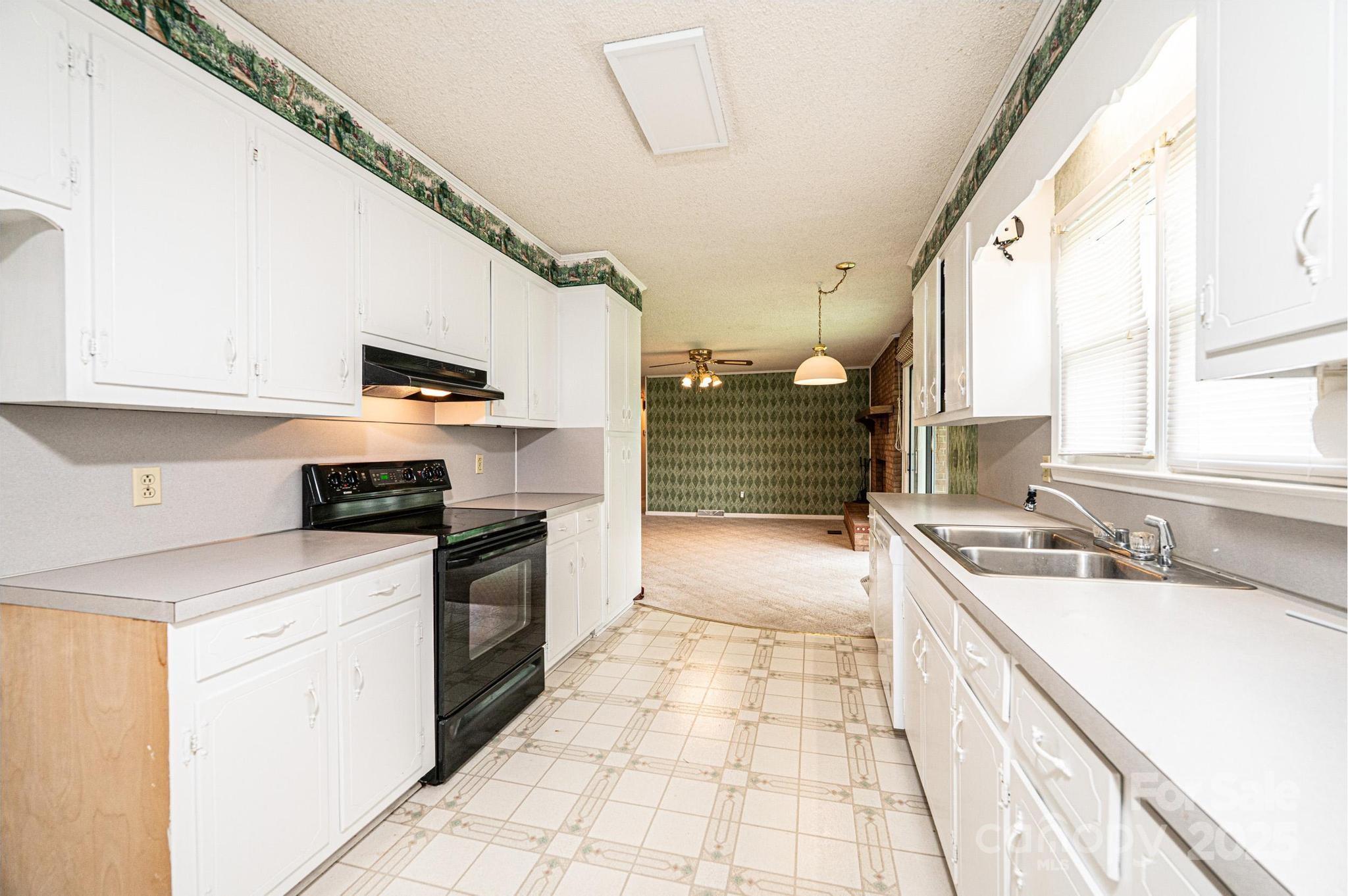 2541 Raintree Street Connelly Springs, NC 28612 - Photo 12 of 46 a kitchen with a sink stove and cabinets