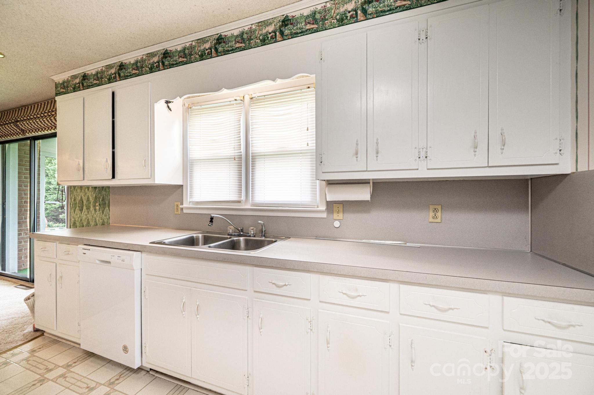 2541 Raintree Street Connelly Springs, NC 28612 - Photo 13 of 46 a kitchen with granite countertop white cabinets and a sink