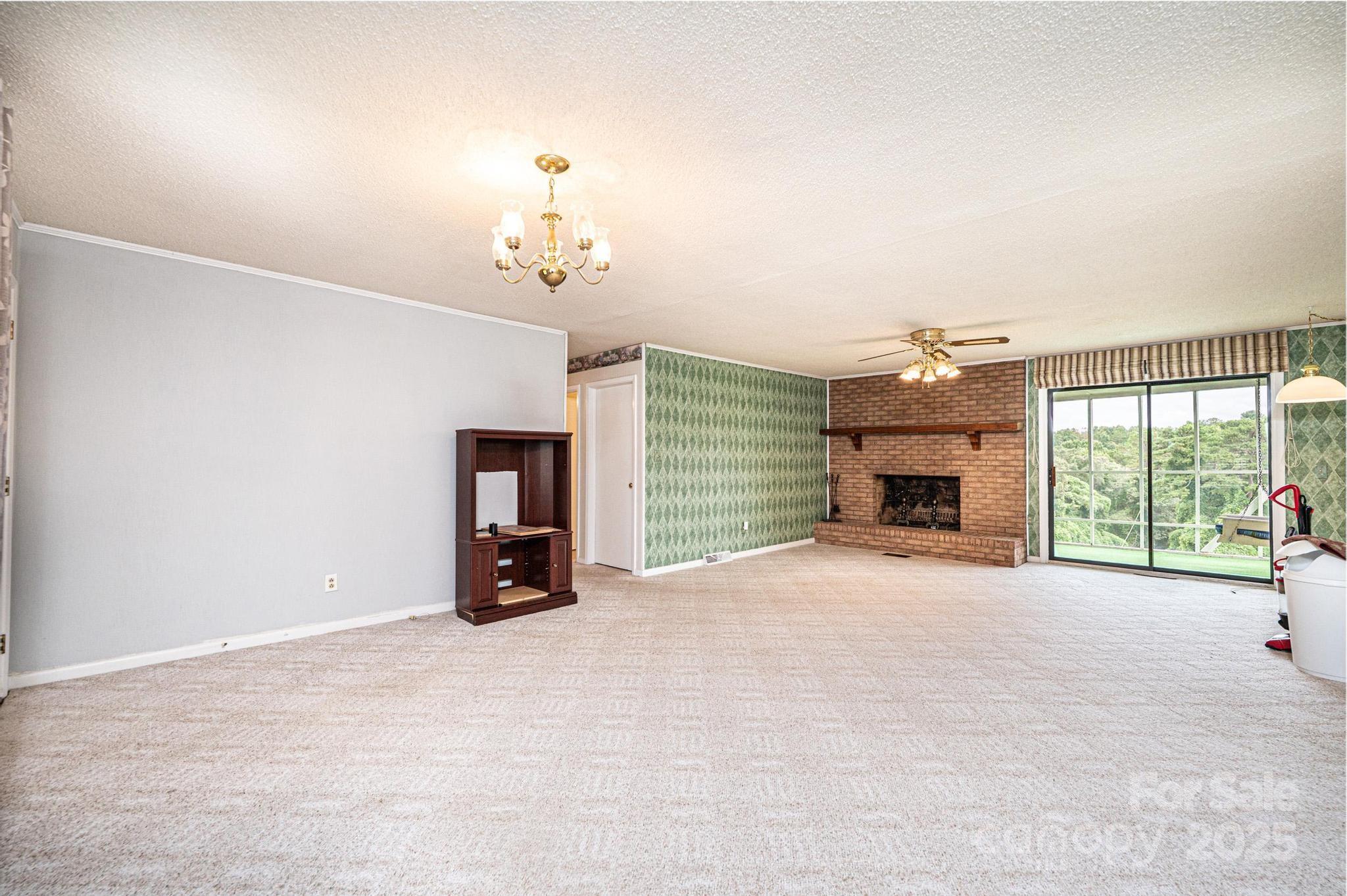 2541 Raintree Street Connelly Springs, NC 28612 - Photo 4 of 46 a view of an empty room with a fireplace and a window