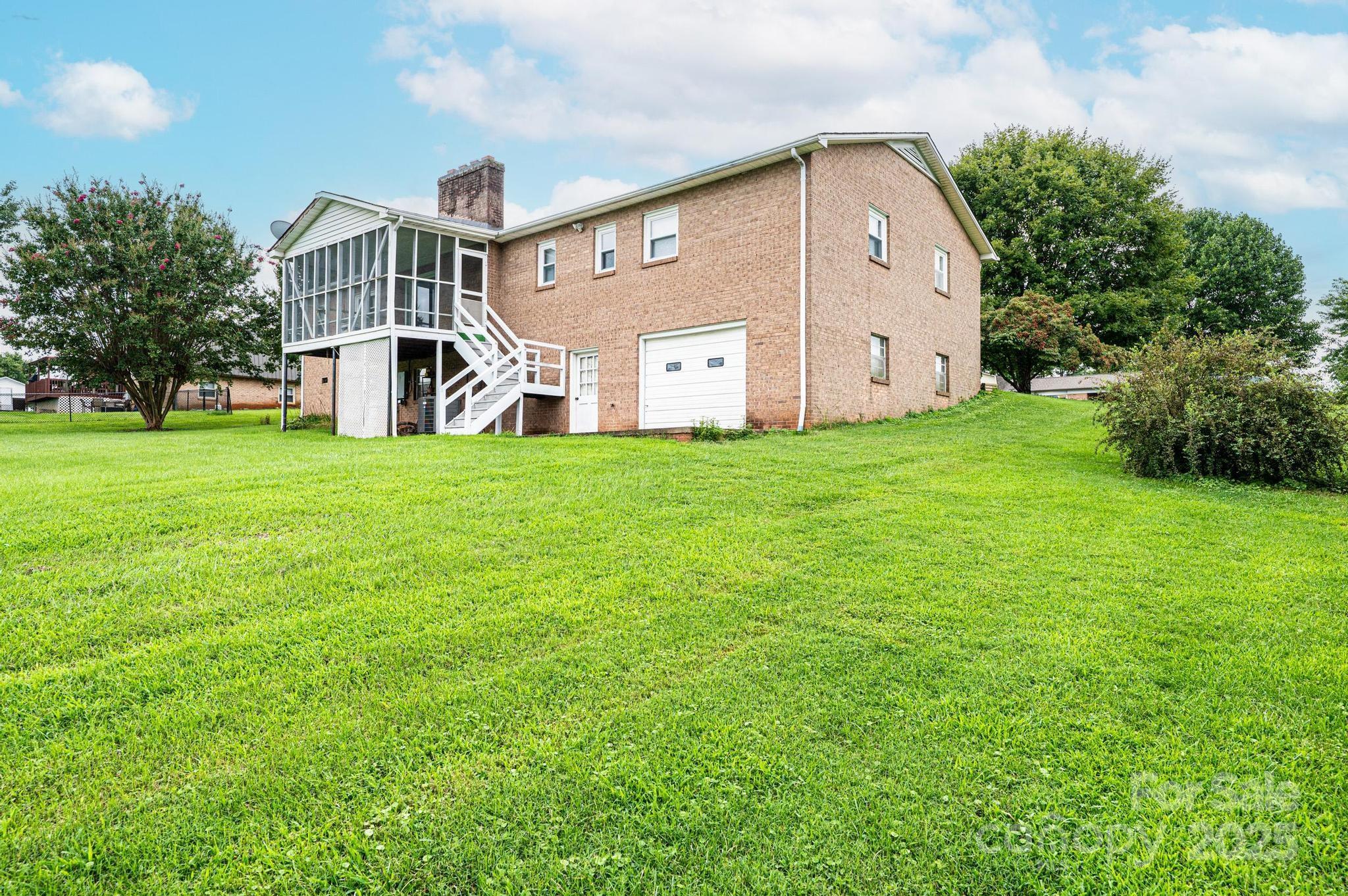2541 Raintree Street Connelly Springs, NC 28612 - Photo 41 of 46 a view of a big house with a big yard and large trees