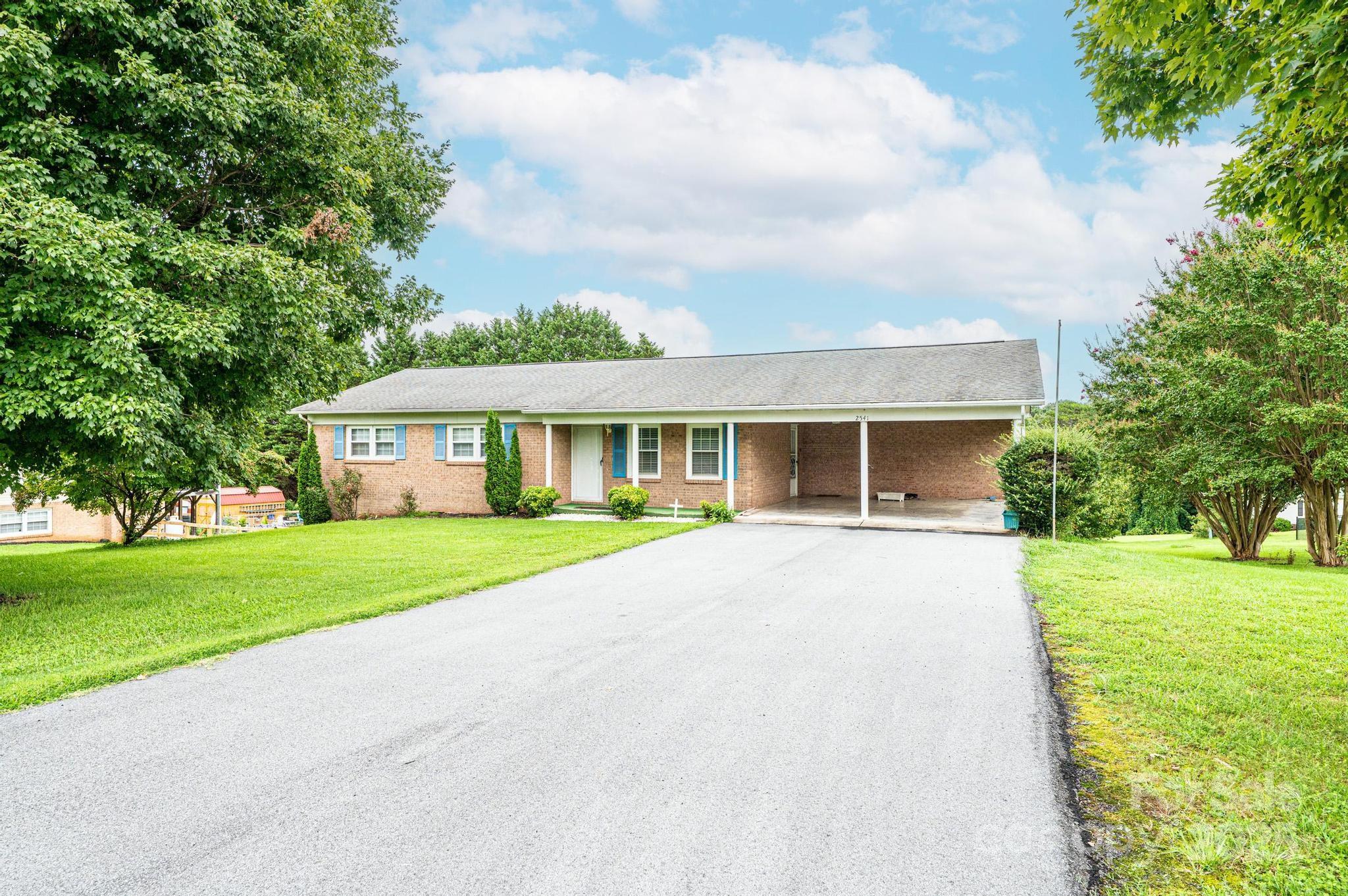 2541 Raintree Street Connelly Springs, NC 28612 - Photo 42 of 46 a front view of a house with a garden and trees
