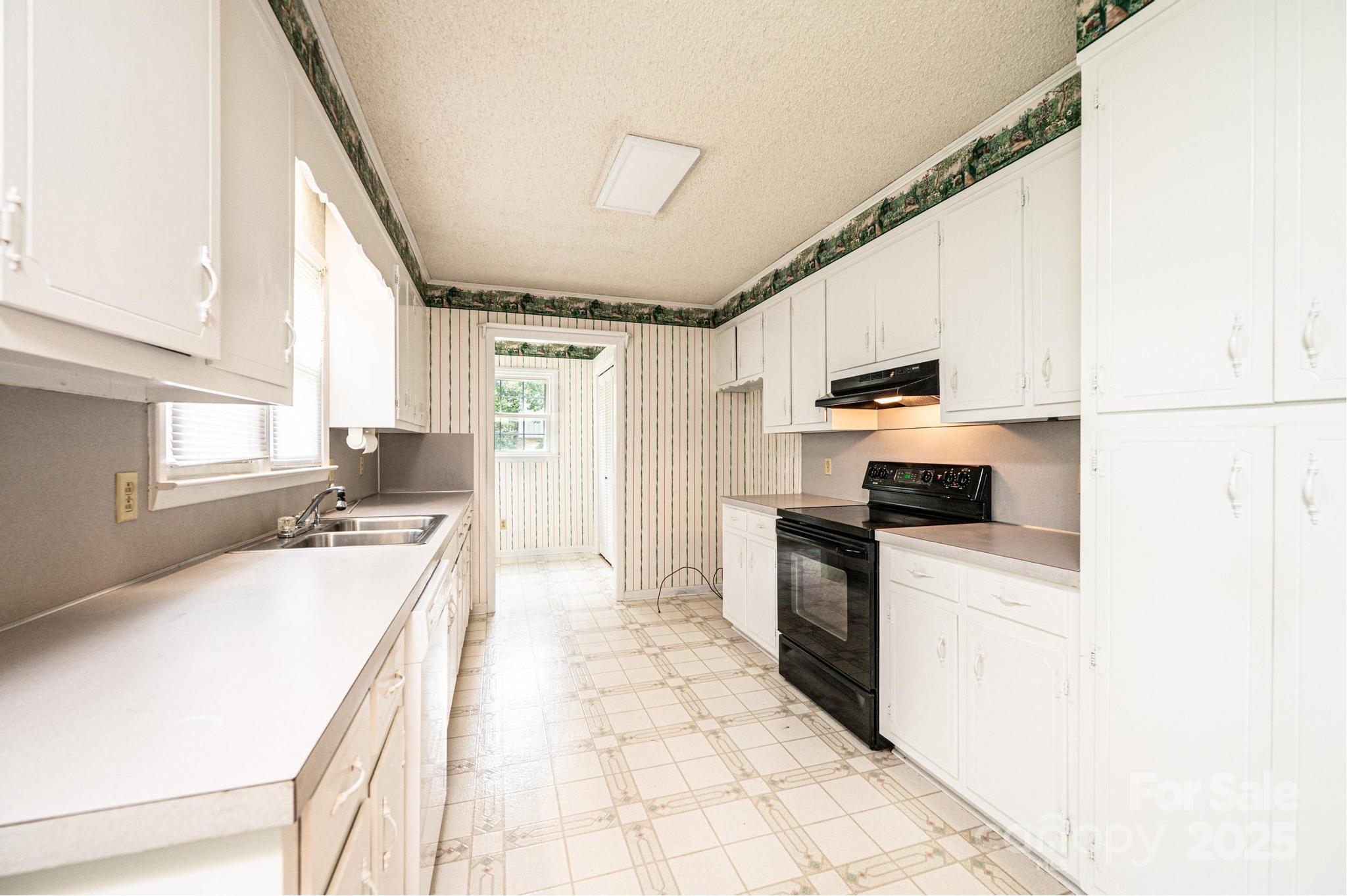 2541 Raintree Street Connelly Springs, NC 28612 - Photo 10 of 46 a kitchen with a sink a stove top oven a counter top space and cabinets