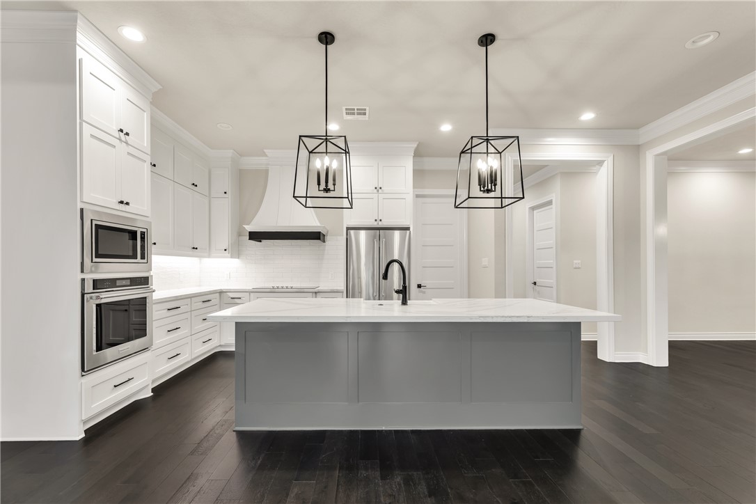 1736 Blanco Bend Drive College Station, TX 77845 - Photo 4 of 36 a kitchen with stainless steel appliances a sink stove and wooden floor